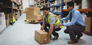 Health & Safety training showing warehouse worker how to properly lift a heavy box.